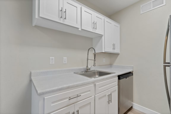 Kitchen with white cabinets and a sink and refrigerator at Elevation Apartments, Tucson