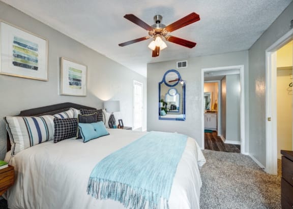 the master bedroom has a large bed and a ceiling fan at Sundance and Sausalito Apartments, College Station, 77840