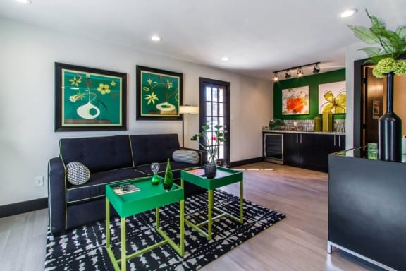 a living room with a black couch and green tables at Sundance and Sausalito Apartments, College Station