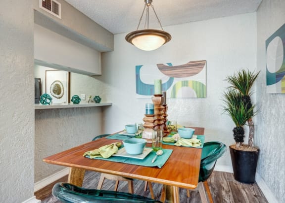 a dining room with a table and chairs and a potted plant at Sundance and Sausalito Apartments, College Station, TX, 77840
