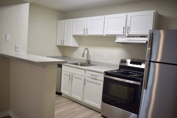 a kitchen with stainless steel appliances and white cabinets