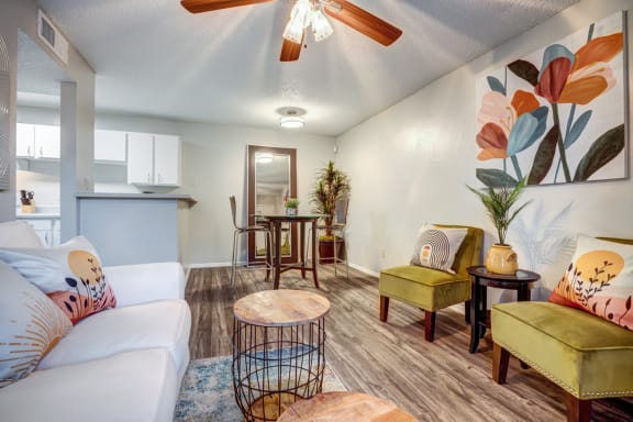 Colorful Living room with a ceiling fan and a kitchen in the background &#xA0;at Willowick Apartments, College Station, Texas