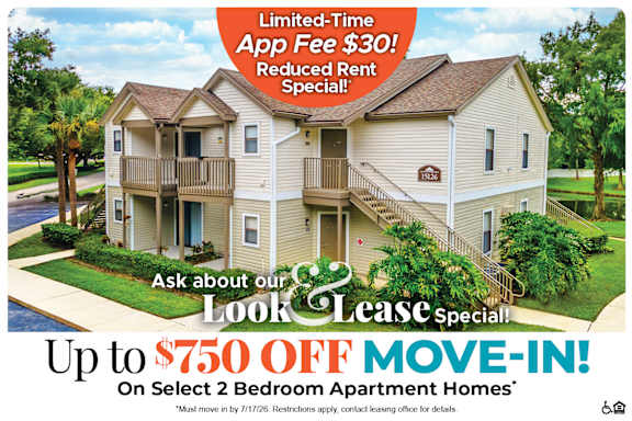 A large two-story apartment building with a red and white advertisement offering a limited-time app fee discount and a move-in special.