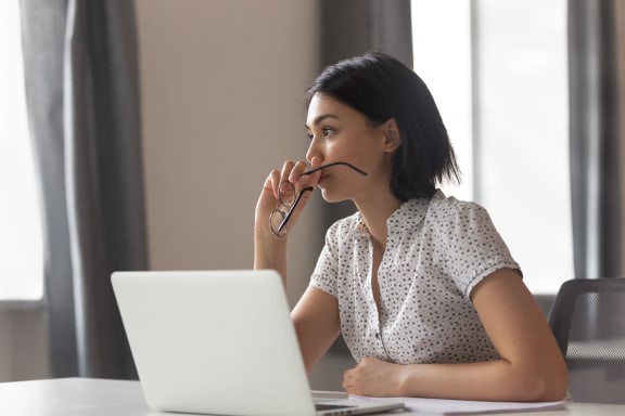 a woman sitting at a table with a laptop computer