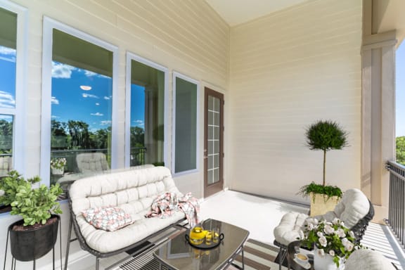 a covered porch with a white couch and a table
