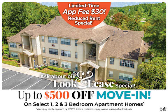 A large, multi-story apartment building with a special offer for a move-in discount.