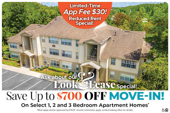 A large apartment complex advertises a limited-time app fee reduction and a move-in special.