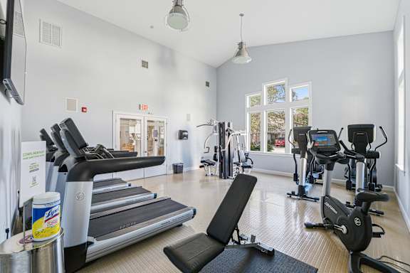 A gym with treadmills, exercise bikes, and other equipment.