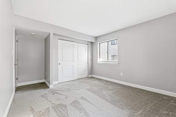 A room with a carpeted floor and a white door.