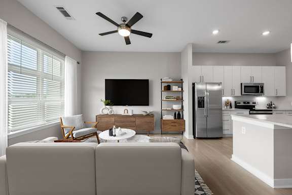 A modern living room with a grey couch and a television.