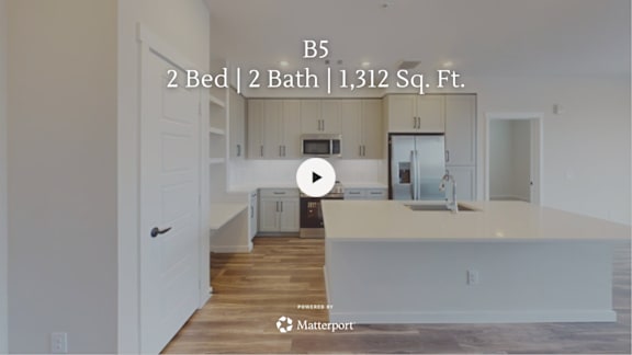 A kitchen with a video play button overlay.