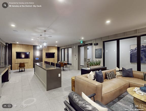 A modern living room with a brown leather couch and a wooden entertainment center.