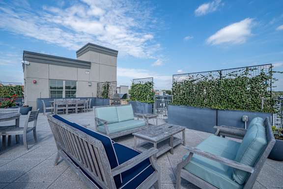 A patio with blue cushions and wooden furniture.