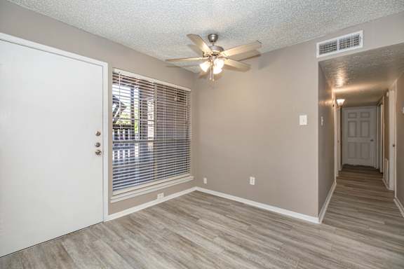 A room with a ceiling fan and a door.