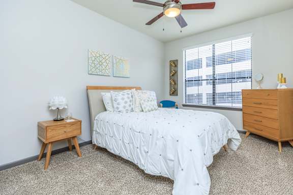 A bedroom with a bed, nightstand, and dresser.