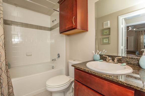 A bathroom with a white toilet and a brown cabinet.