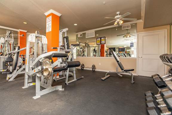 A gym with a variety of equipment including a leg press machine.