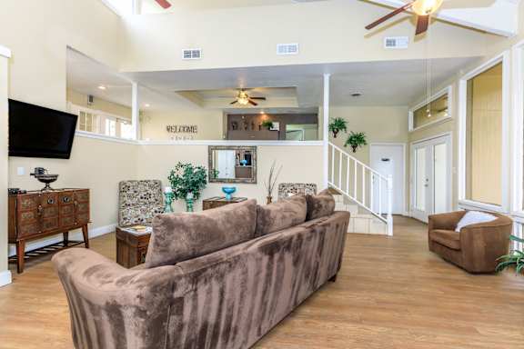 A living room with a brown couch and a flat screen TV.