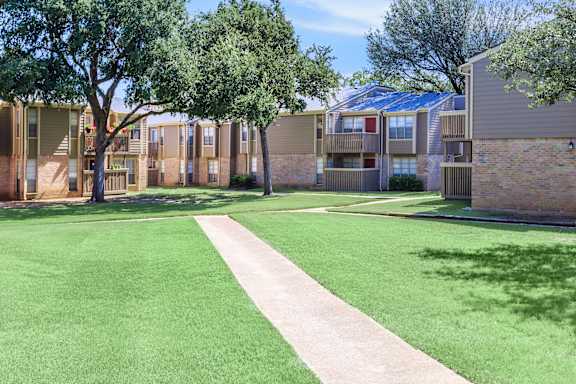 A grassy area in front of apartment buildings.