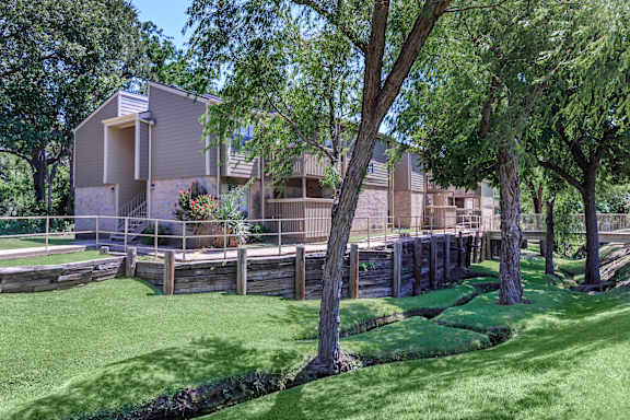 A large house with a grey roof and a green lawn in front.