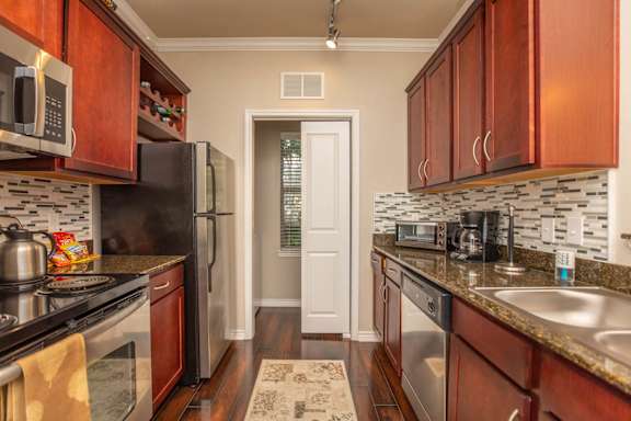 A kitchen with dark wood cabinets and granite countertops.