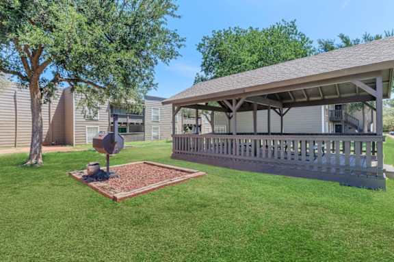 a covered porch with a stop sign in the grass