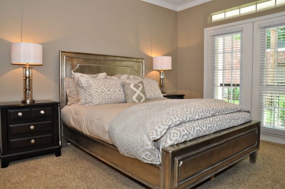a bedroom with a bed and two lamps and a window