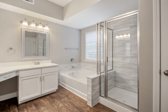 a bathroom with a tub and a shower and a sink