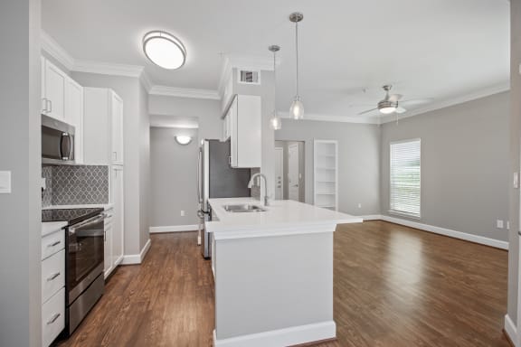 an open kitchen and living room with a white counter top