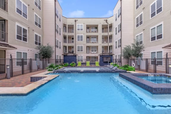 a large swimming pool in front of an apartment building