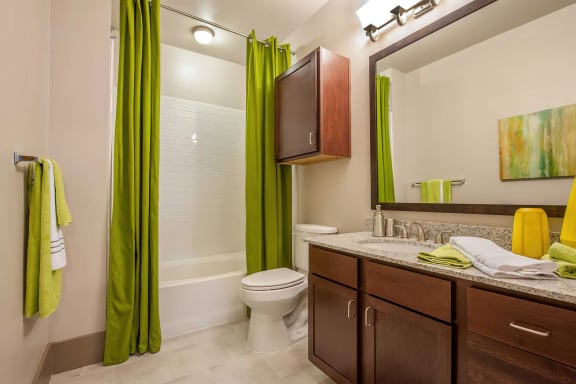 a bathroom with a green curtain and a toilet and a sink