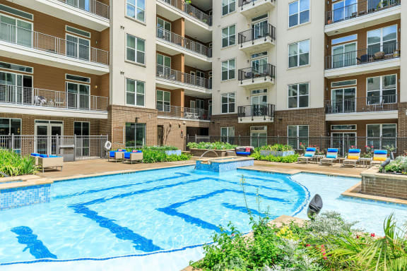 a large swimming pool in front of an apartment building
