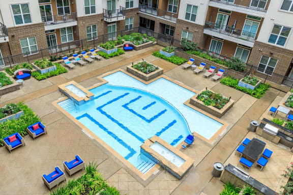 an aerial view of a large swimming pool in front of an apartment building