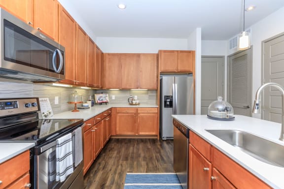 a kitchen with wooden cabinets and stainless steel appliances