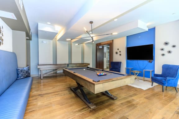 a pool table in a living room with a blue couch