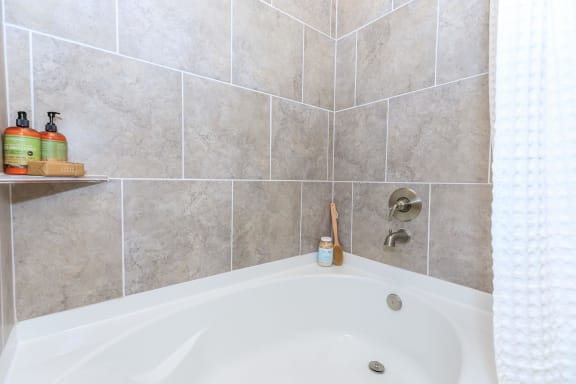 a bathroom with a bath tub and tiled walls