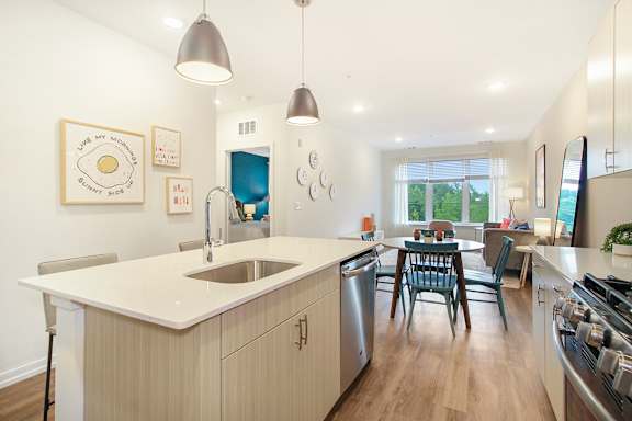 A modern kitchen with a large island and pendant lights.