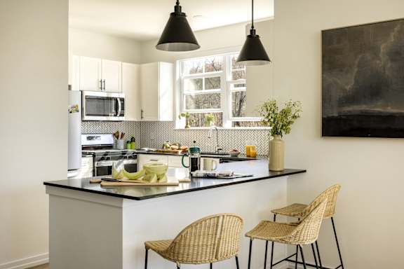 a kitchen with a counter top and three stools