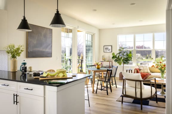 a kitchen with a counter top and a dining room with a table and chairs