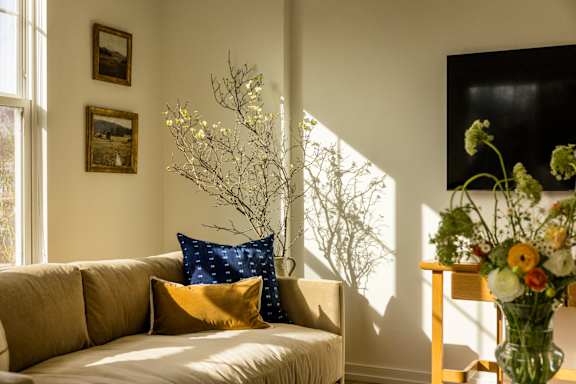 a living room with a couch and a vase of flowers
