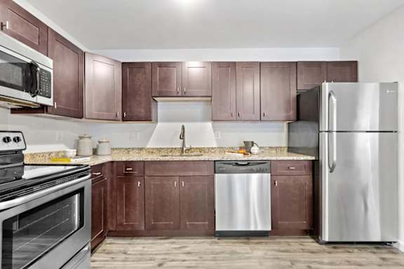 A kitchen with brown cabinets and stainless steel appliances.