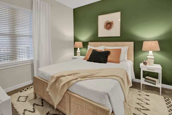 A bedroom with a bed, nightstand, and lamp.