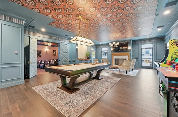 A billiard table is in the middle of a room with a patterned ceiling. at Maison Apartments, Westerville, 43081