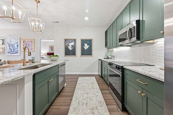 A kitchen with green cabinets and a marble countertop. at Maison Apartments, Ohio