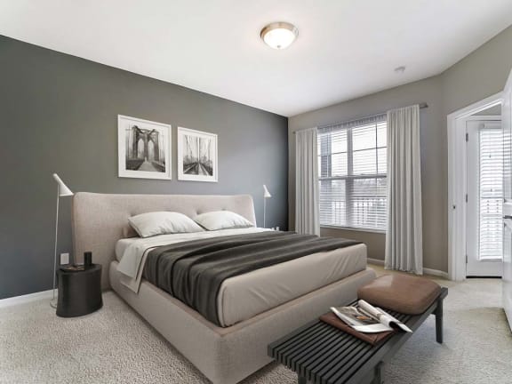 a bedroom with a bed and a table in front of a windowat Madison Park Apartments, Columbus, OH, 43214