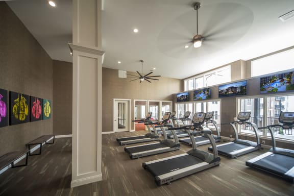 a gym with treadmills and televisions on the wallat Madison Park Apartments, Columbus, Ohio