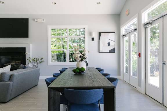 A dining room with a long table and blue chairs.