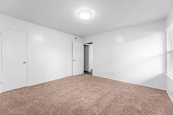 A room with a carpeted floor and white walls.