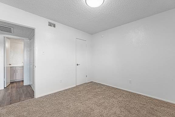 A room with a carpeted floor and a door.