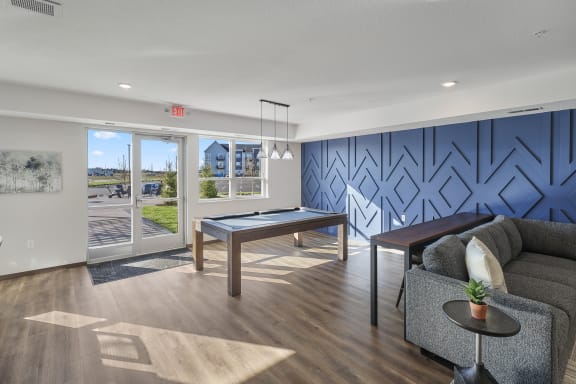 a living room with a pool table and a blue accent wall